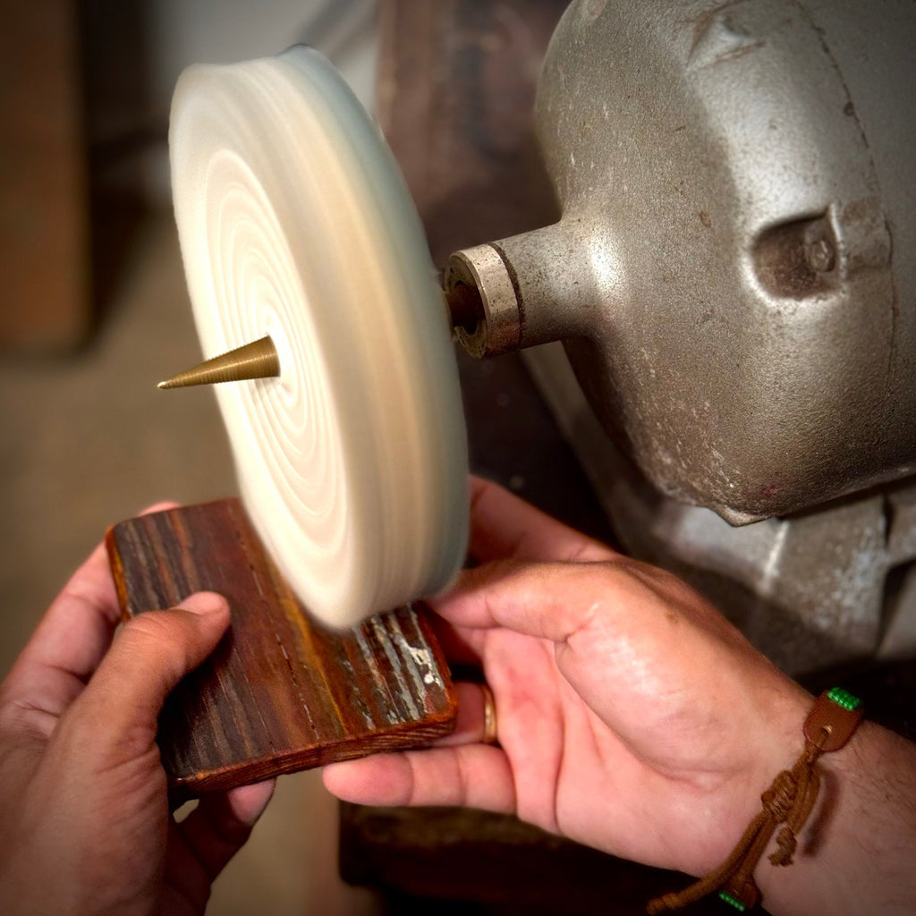 Hand polishing a reclaimed heart pine coaster during the finishing process