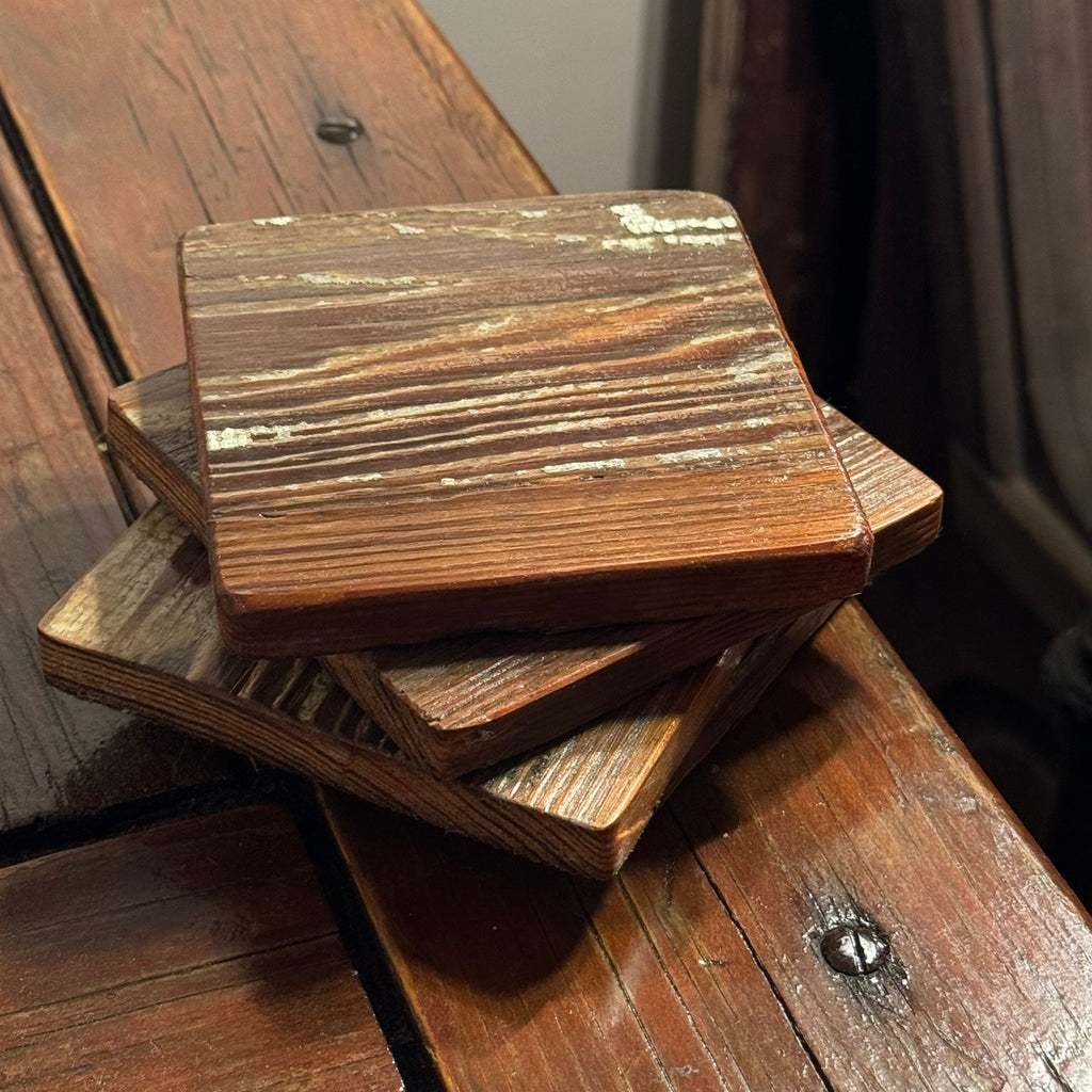 Stacked handmade reclaimed heart pine coaster set showing old paint and grain