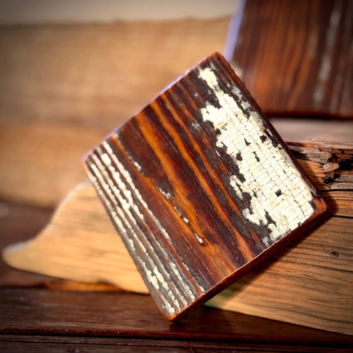 Single handmade heart pine coaster showing preserved old paint and reclaimed wood grain